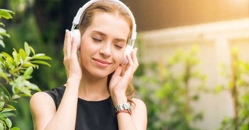 Active Listening - Woman Wearing Black Sleeveless Dress Holding White Headphone at Daytime
