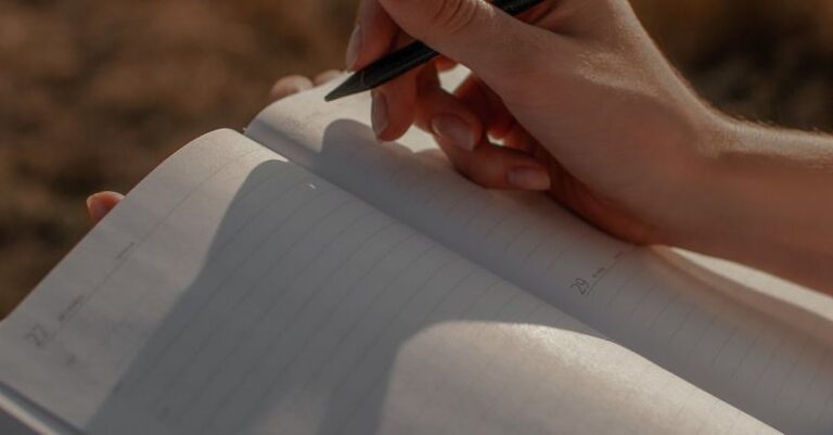 Bullet Journaling - Close-up of Woman Writing in a Journal Outdoors