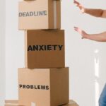 Decision Matrix - Man near carton boxes with many different words about stress